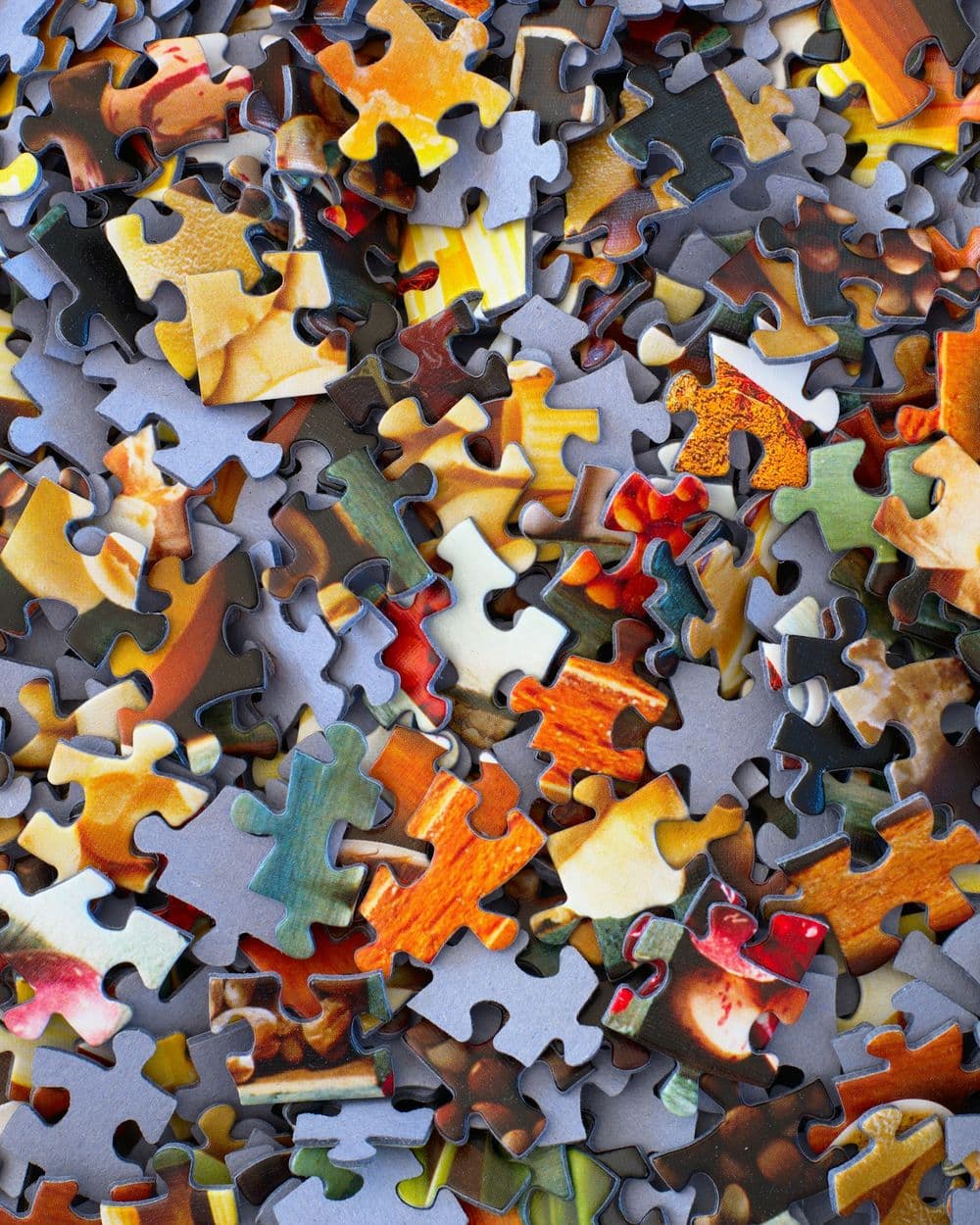 Colorful jigsaw puzzle pieces piled together, seen from above
